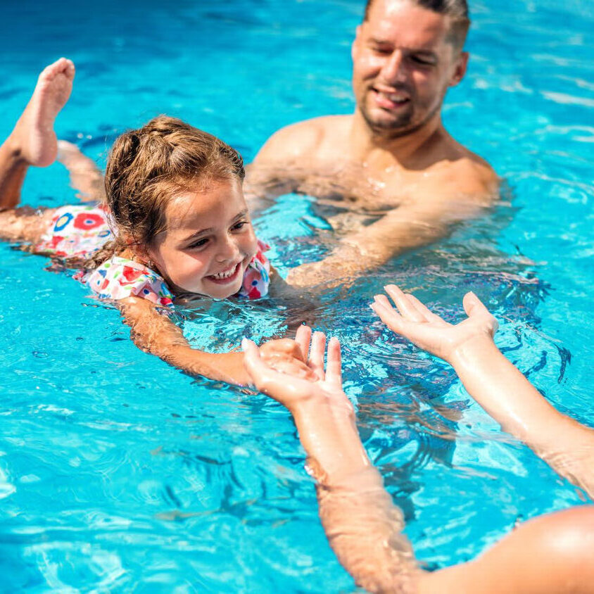 rodzina kąpiąca się w basenie